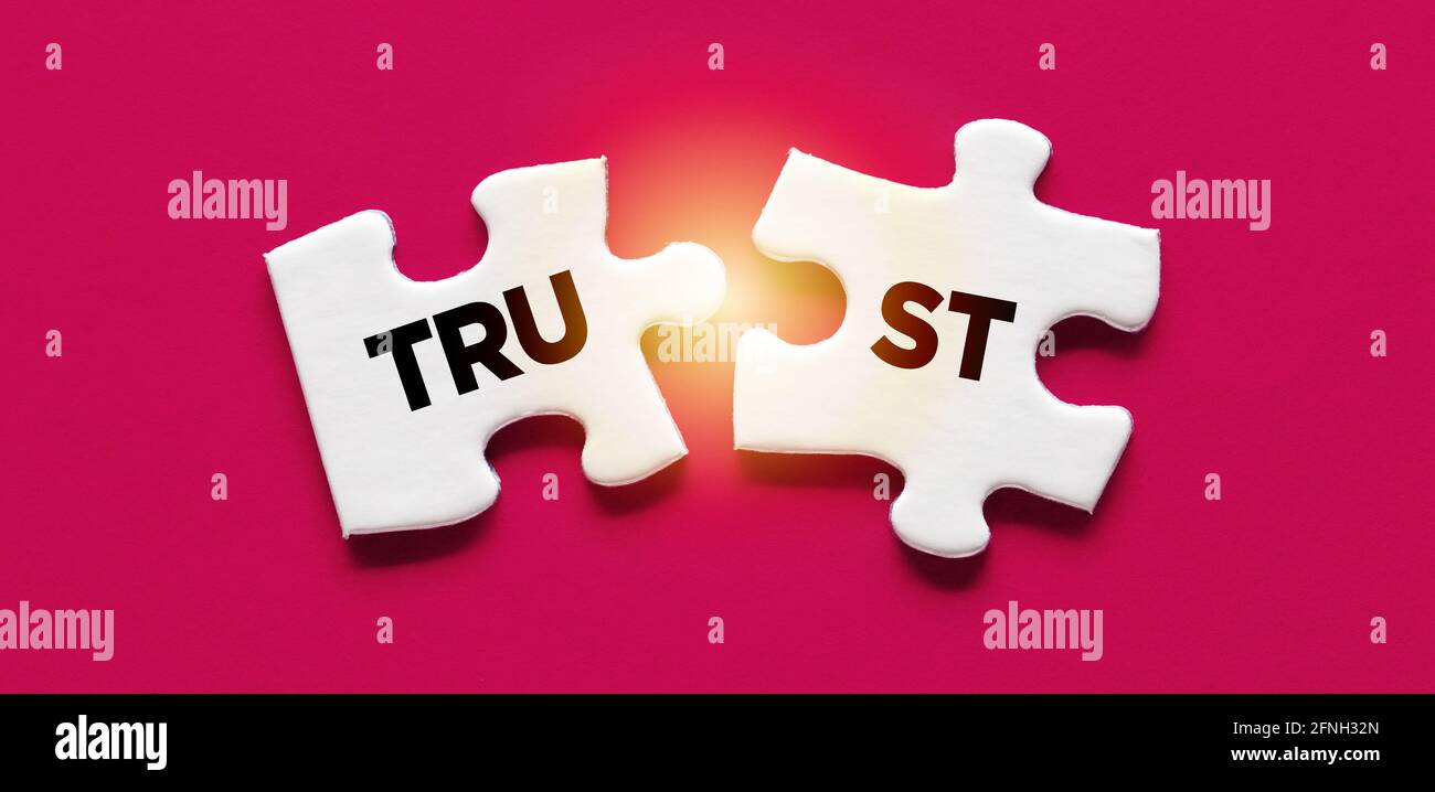 Zwei getrennte Puzzleteile mit dem Wort Vertrauen. Gebrochenes Vertrauen, um Vereinbarungen zu verletzen, um Glaubwürdigkeit und Reputationskonzept zu verlieren. Stockfoto