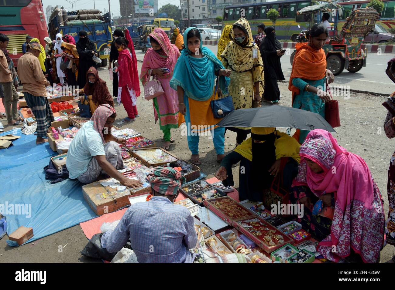 DHAKA, BANGLADESCH – MAI: Am Ende des Eid-Feiertages kaufen einige Bekleidungsarbeiter Ornamente von Händlern vor den Bekleidungsfabriken in S Stockfoto