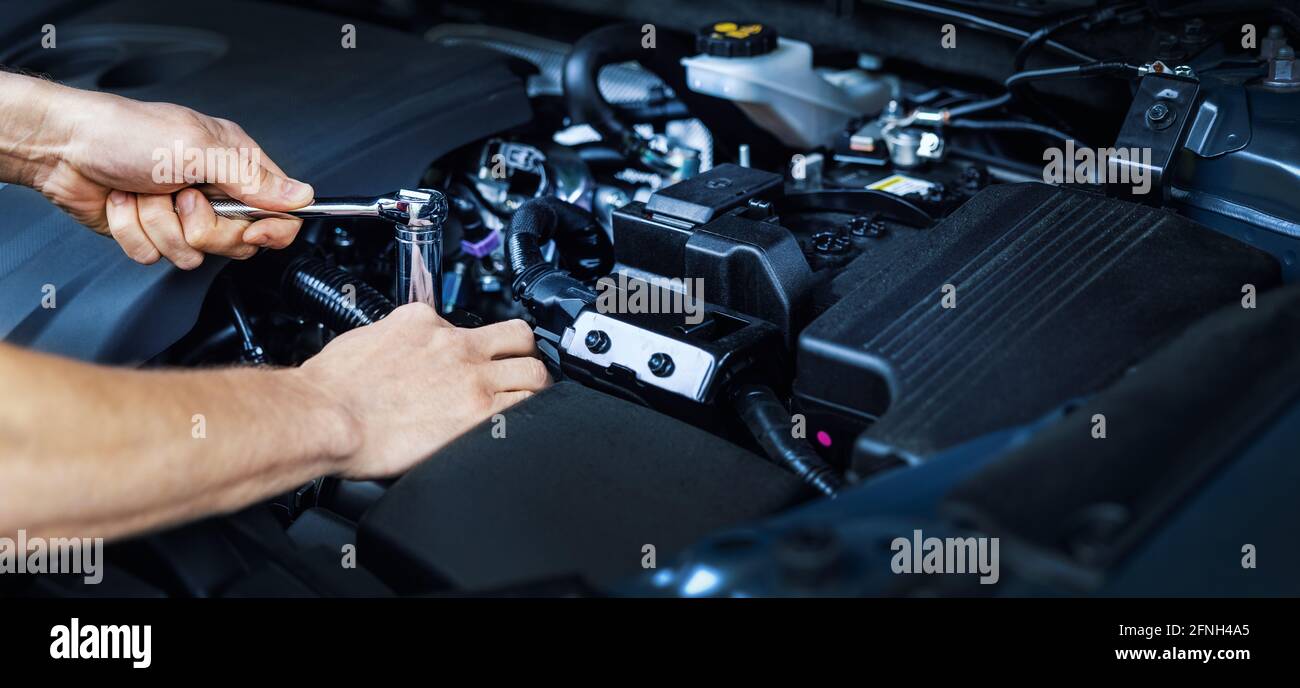 Mechaniker arbeitet mit Schraubenschlüssel auf Fahrzeugmotor im Autoservice. Wartung und Reparatur. Banner Copy Space Stockfoto