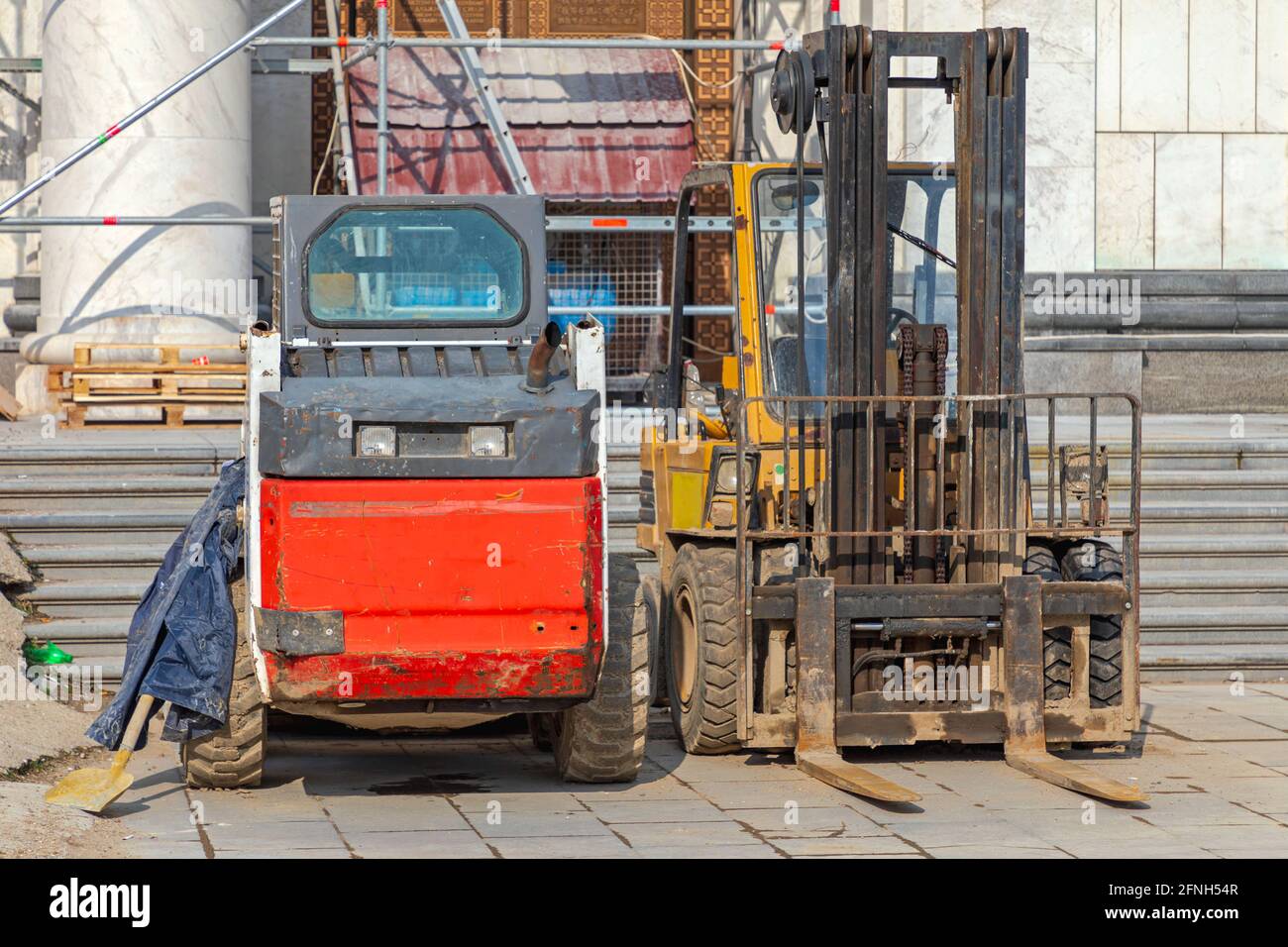 Kompaktlader und Gabelstapler auf der Baustelle Stockfoto