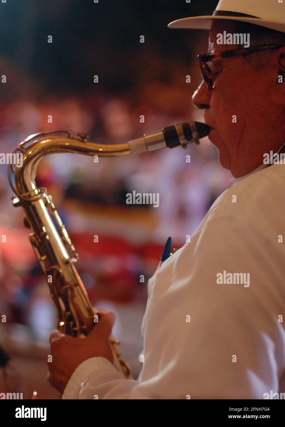 Ein Musiker, der einen Saxophonrückblick spielt. Flacher Fokus auf die Vorderhand und das Gesicht, wobei der Rest des Abschnitts in die Unschärfe des Rückens fällt Stockfoto