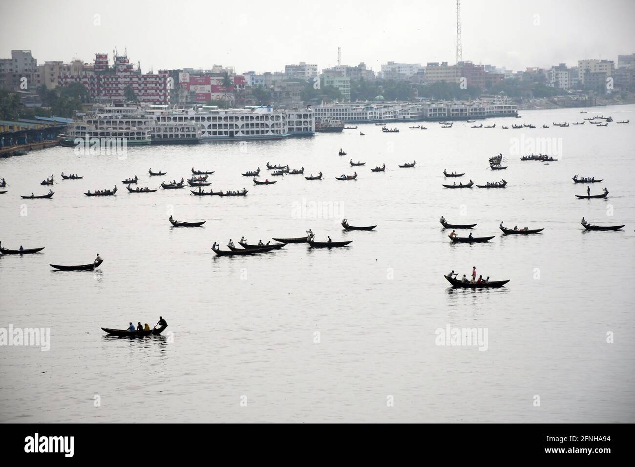 DHAKA, BANGLADESCH – MAI: Am 2021. Mai werden kleine Holzboote gesehen, die Passagiere transportieren, um den Buriganga River in Dhaka, Bangladesch zu überqueren. Stockfoto