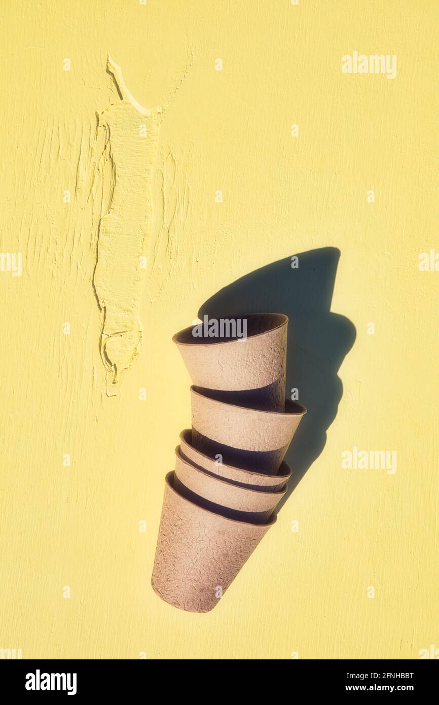 Stapel von biologisch abbaubaren Faser Torfpflanzen Töpfe auf gelbem strukturiertem Hintergrund. Konzept ohne Kunststoffe, nachhaltig, umweltfreundlich, Stockfoto