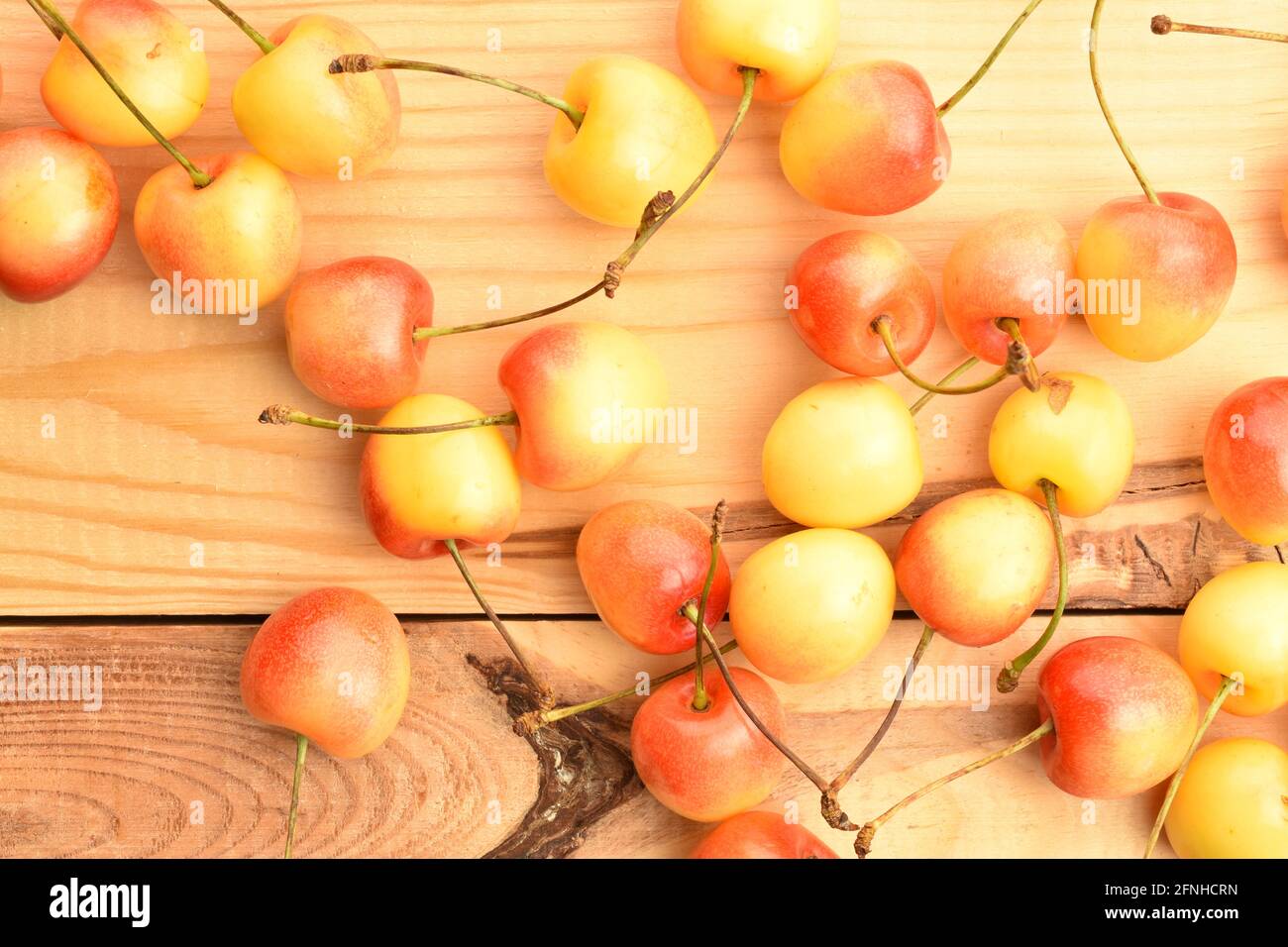 Saftige Bio-Kirsche, gelbe Süßkirsche, Nahaufnahme, auf einem Holztisch, Draufsicht. Stockfoto