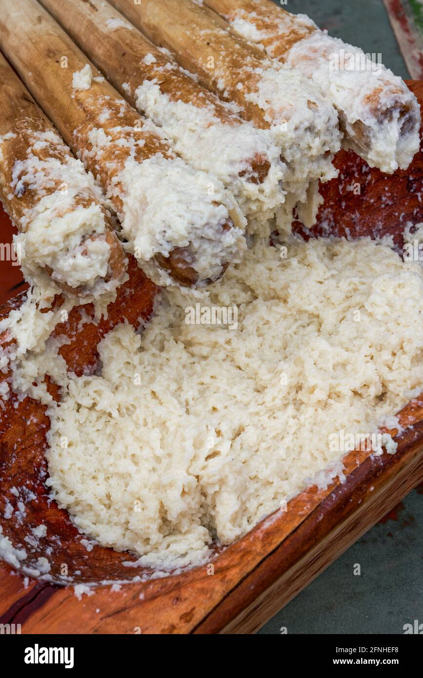 Eine Gruppe von Menschen, die mit Holzstäben klebrigem Reis hammerten Für die Herstellung von Reiskuchen mit Merkmalen der Guangxi Zhuang Nationalität Stockfoto