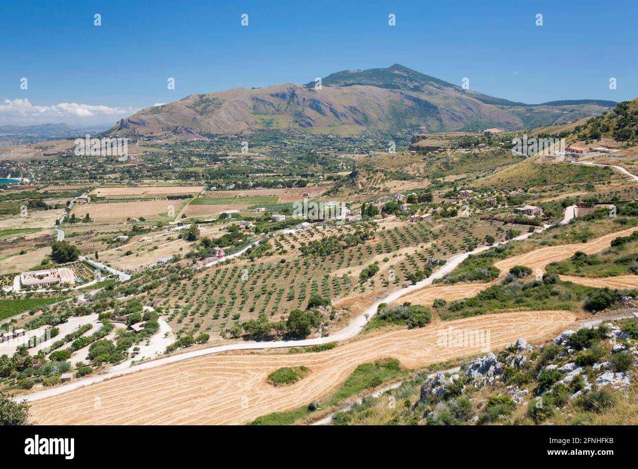 Scopello, Trapani, Sizilien, Italien. Blick über die landwirtschaftlich typische Landschaft vom Torre Bennistra, Monte Inici im Hintergrund. Stockfoto