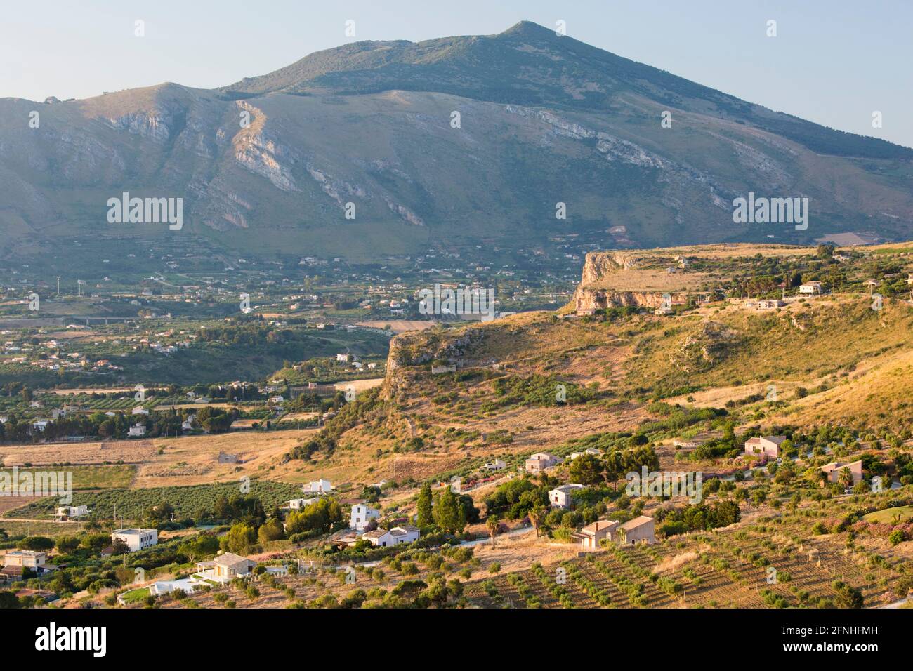 Scopello, Trapani, Sizilien, Italien. Blick über die landwirtschaftlich typische Landschaft vom Torre Bennistra, Sonnenaufgang, Monte Inici im Hintergrund. Stockfoto