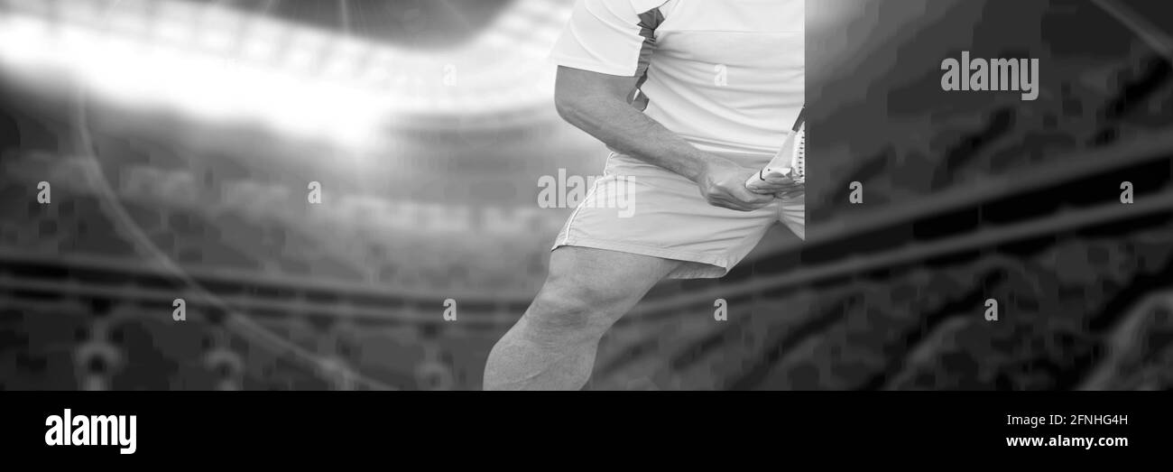 Komposition des Mittelteils des Mannes, der Tennis über einem Sportstadion spielt, in Schwarz-Weiß. Sport- und Active Lifestyle-Konzept digital generiertes Bild. Stockfoto
