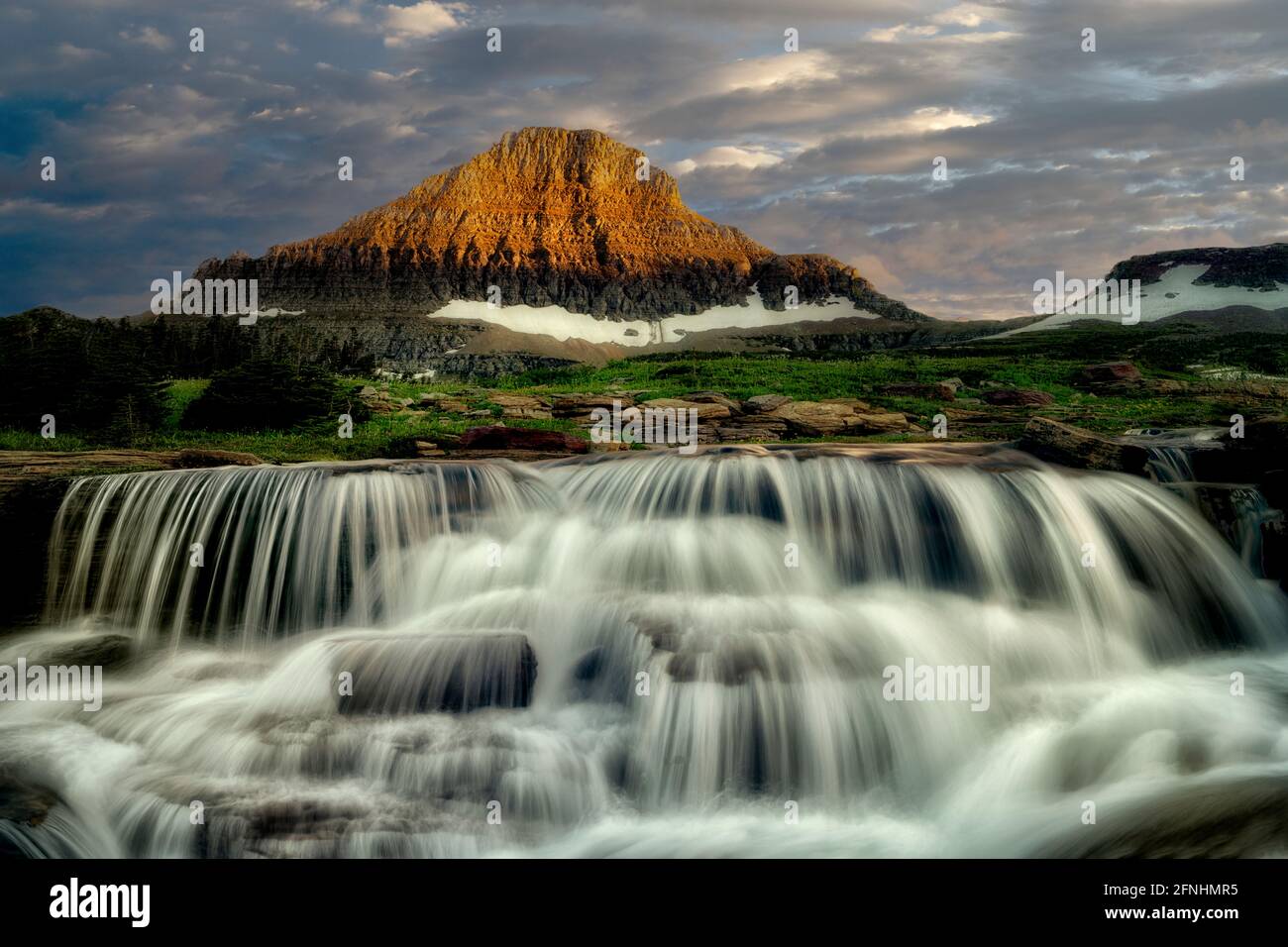 Reynolds Creek mit Spring Wasserfall am Creek bei Sonnenuntergang. Glacier National Park, Montanna Stockfoto