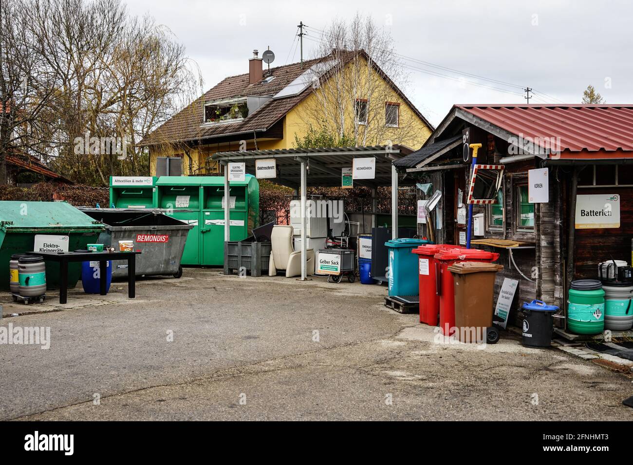 Ein Recyclingzentrum in einer Kleinstadt mit zahlreichen Behältern unterschiedlicher Größen für verschiedene Wertstoffe. Stockfoto