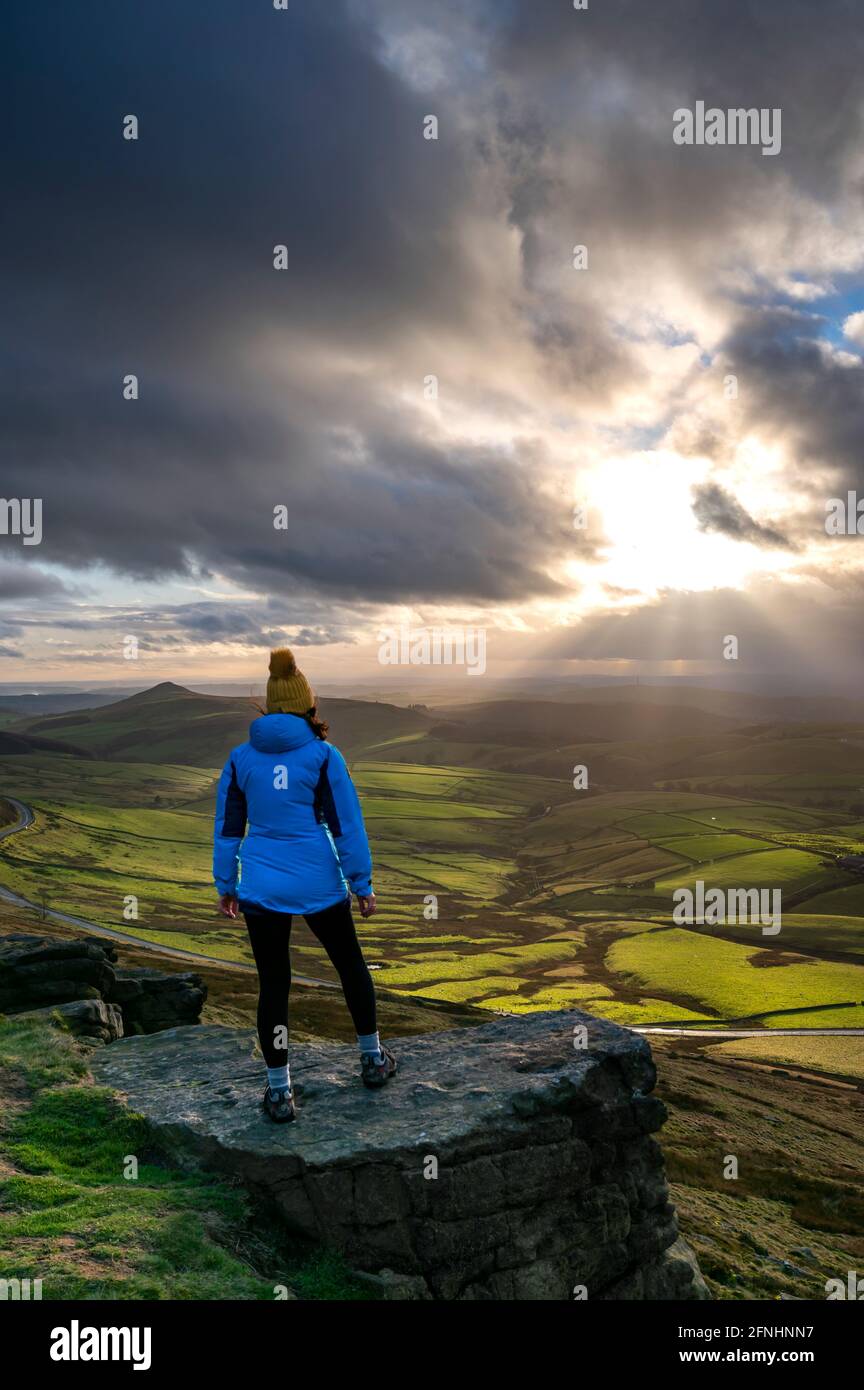 Weibliche Walkerin, die in Richtung Shutlingsloe mit dramatischem Himmel schaut, Shining Tor, Chashire Stockfoto