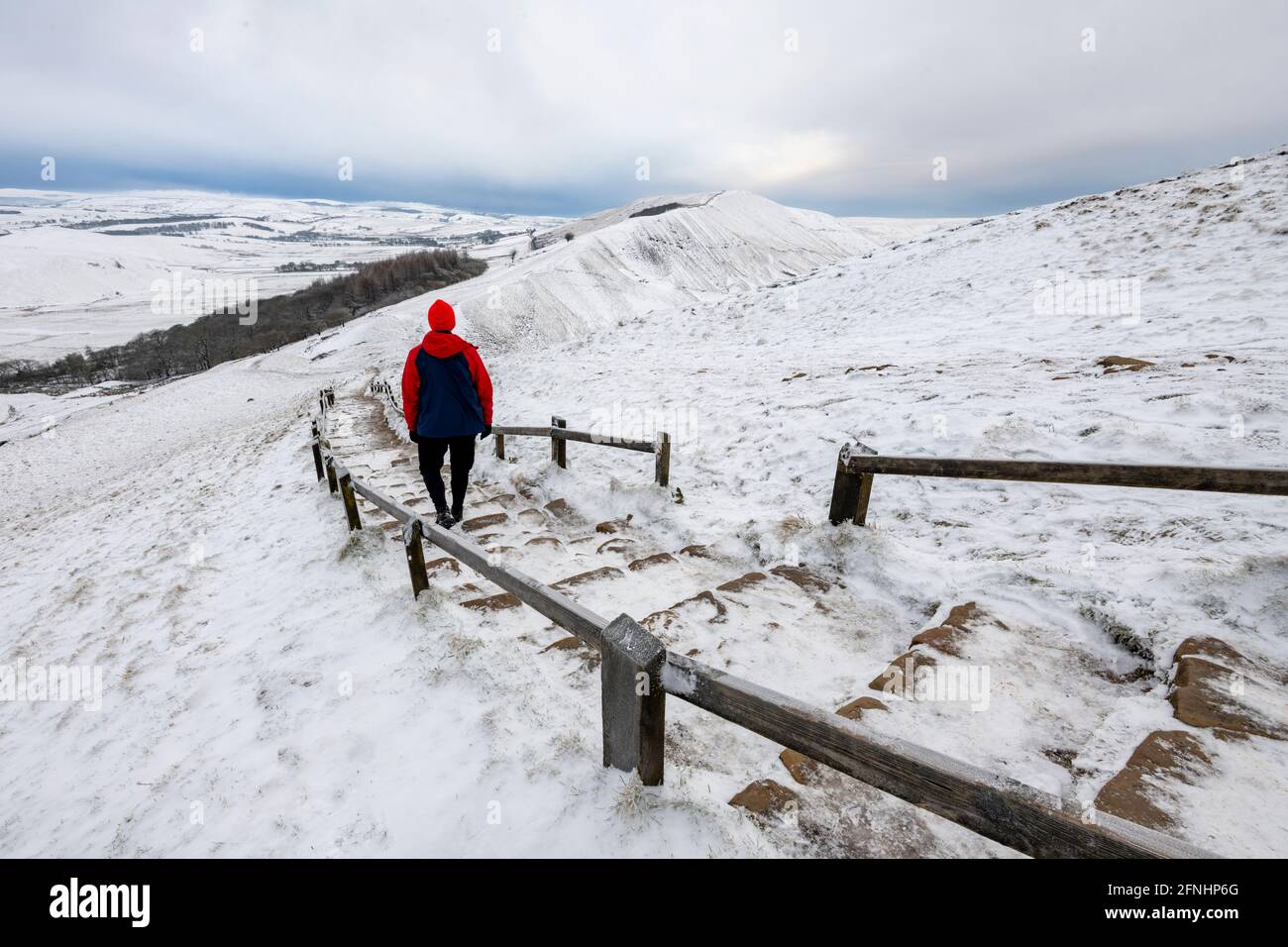 Ein Spaziergänger im Winter, der vom Mam Tor, Peak District, Derbyshire in Richtung Rushup Edge geht Stockfoto