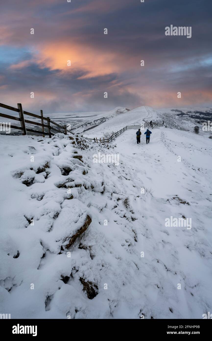 Wanderer im Schnee auf dem Great Ridge, die von Mam Tor, Derbyshire, in Richtung Losehill wandern Stockfoto