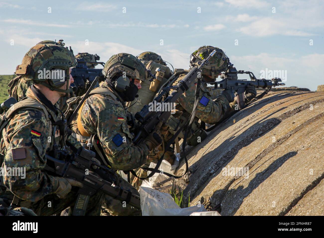 Deutsche Soldaten, die dem 31. Fallschirmjäger-Regiment, 1. Luftbrigade, zugewiesen wurden, nehmen während der Übung Swift Response 21 im Babadag-Trainingsgebiet, 15. Mai 2021 in Babadag, Rumänien, Kampfpositionen hinter einem Bunker ein. Stockfoto