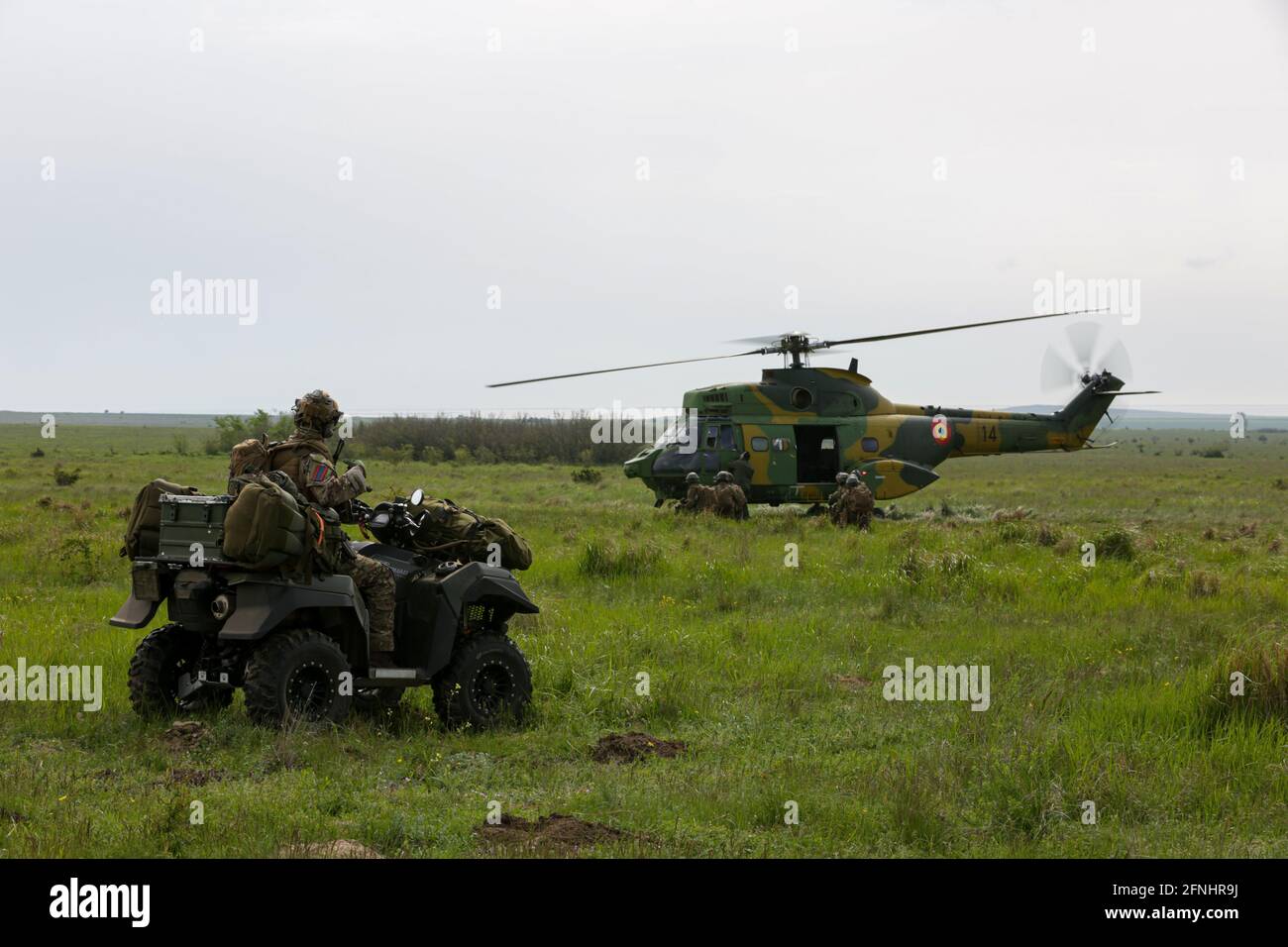 Ein niederländischer Soldat, der dem 11. Luftwaffenbataillon zugewiesen wurde, beobachtet, wie sich Soldaten von Task Force Falcon während der Übung Swift Response 21 auf dem Babadag Trainingsgelände am 16. Mai 2021 in Babadag, Rumänien, darauf vorbereiten, einen rumänischen Puma-Hubschrauber zu laden. Stockfoto