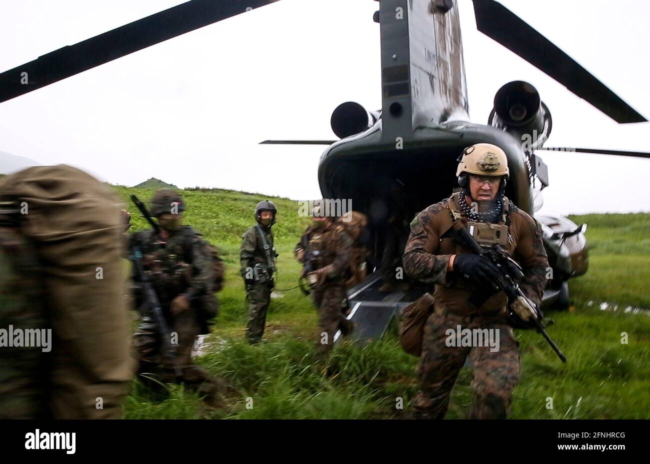 US-Marineinfanteristen mit der III. Marine Expeditionstruppe und japanische Soldaten mit amphibischer Schnelleinsatzbrigade verlassen einen JSDF CH-47 Chinook-Hubschrauber während einer multilateralen Angriffsübung Jeanne D’Arc 21 im Kirishima-Manövergebiet, 15. Mai 2021 in Yamato, Kumamoto, Japan. Stockfoto