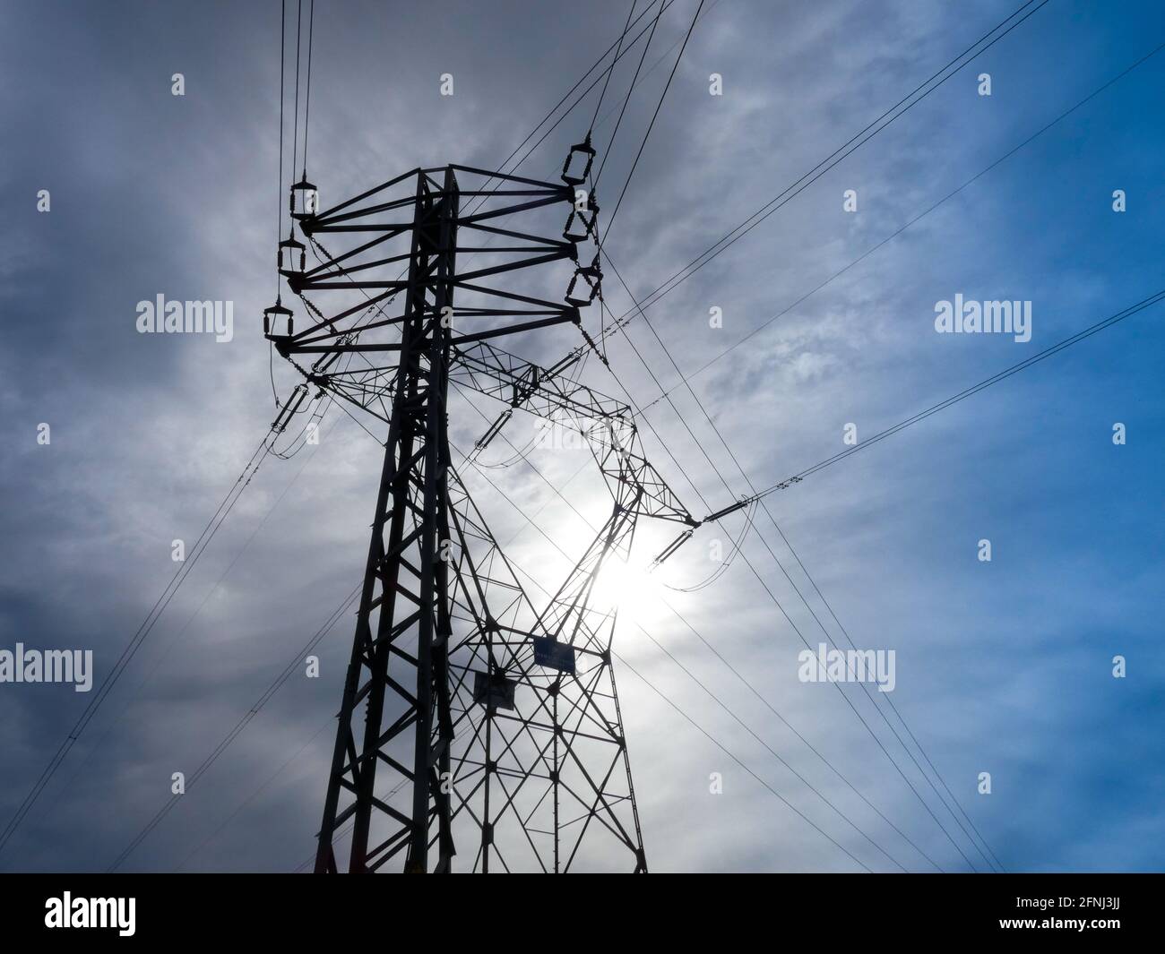 Technische Metalltürme, die elektrische Energie an verschiedene Orte der Geographie transportieren, um Strom an Häuser und Unternehmen zu liefern. Stockfoto