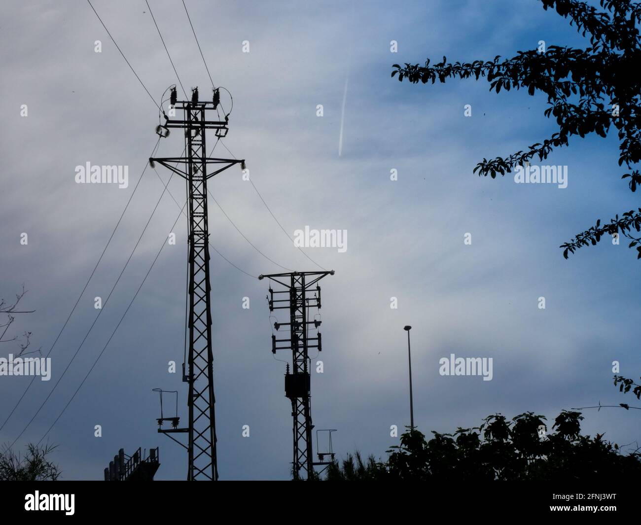 Technische Metalltürme, die elektrische Energie an verschiedene Orte der Geographie transportieren, um Strom an Häuser und Unternehmen zu liefern. Stockfoto