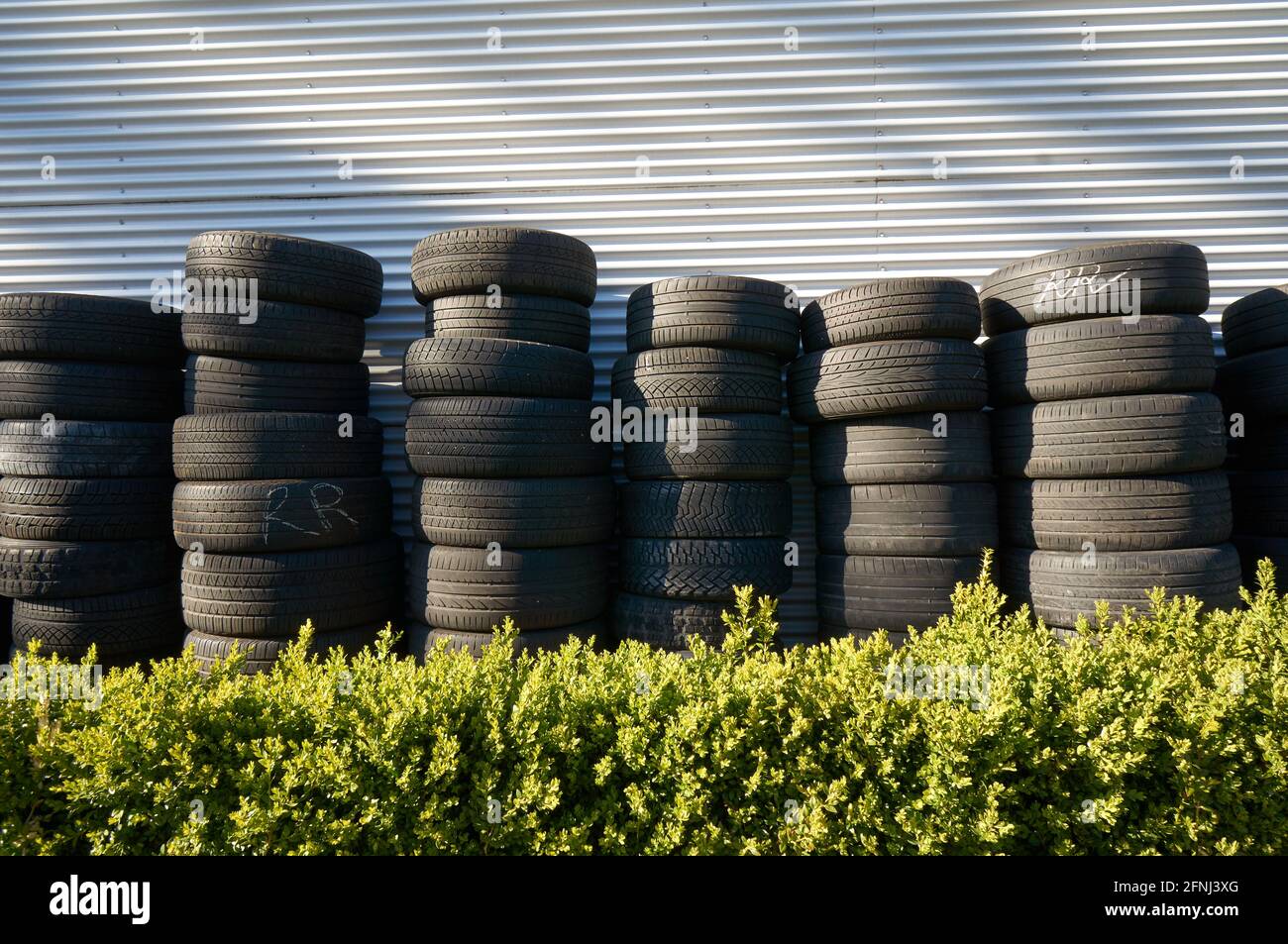 Stapel von gebrauchten Pkw- und Lkw-Reifen außerhalb eines Automobils Service-Garage Stockfoto