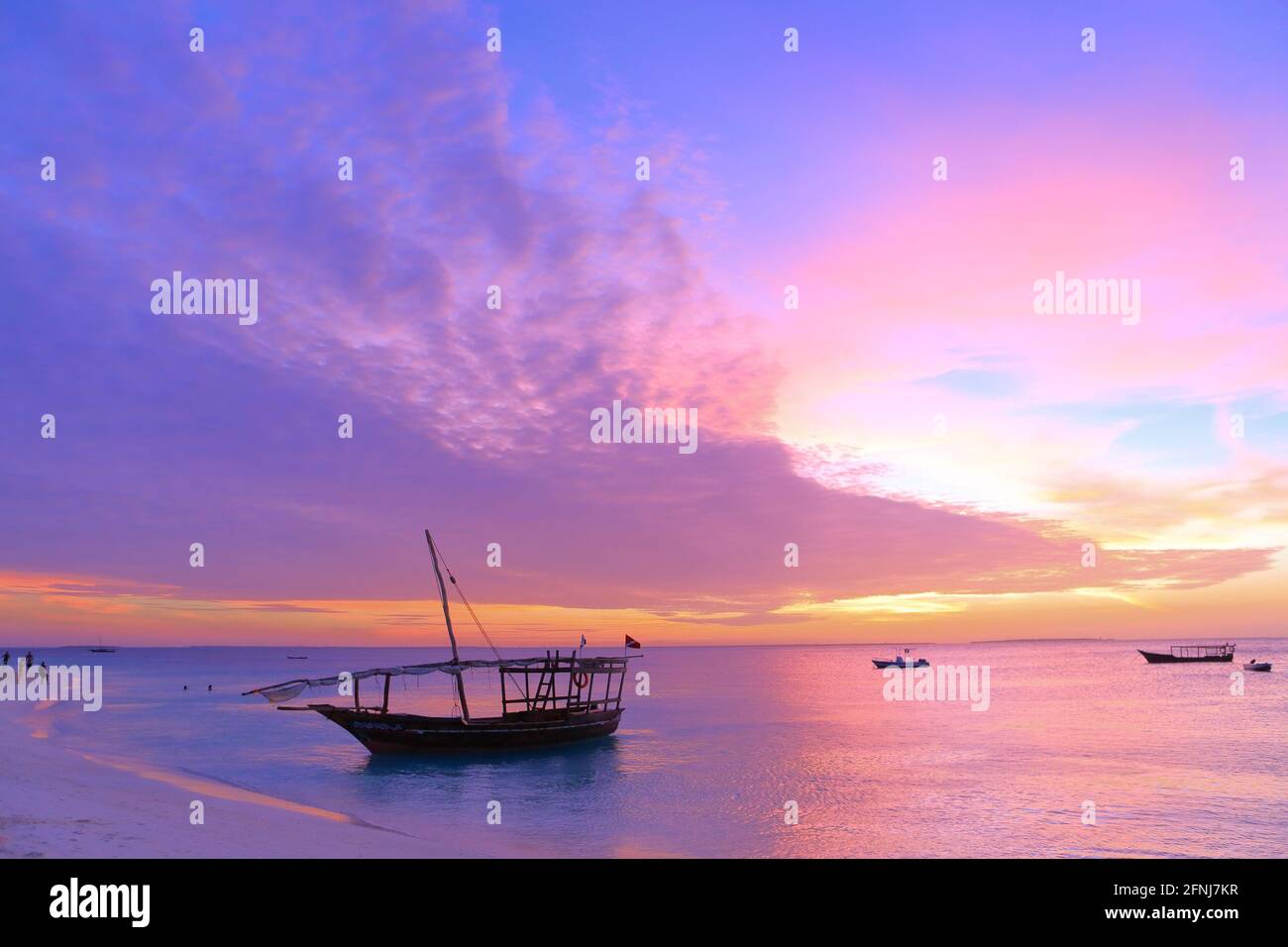 Sonnenuntergang auf Sansibar. Authentisches afrikanisches Holzboot an der malerischen Küste des Ozeans Stockfoto