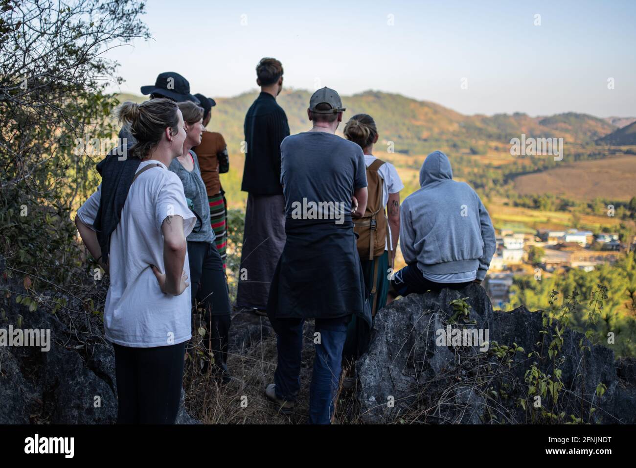 Shan State, Myanmar - Januar 6 2020: Eine Touristengruppe blickt auf ein kleines Bauerndorf, während sie sich auf einer Wanderung von Kalaw zum Inle Lake ausruhen Stockfoto