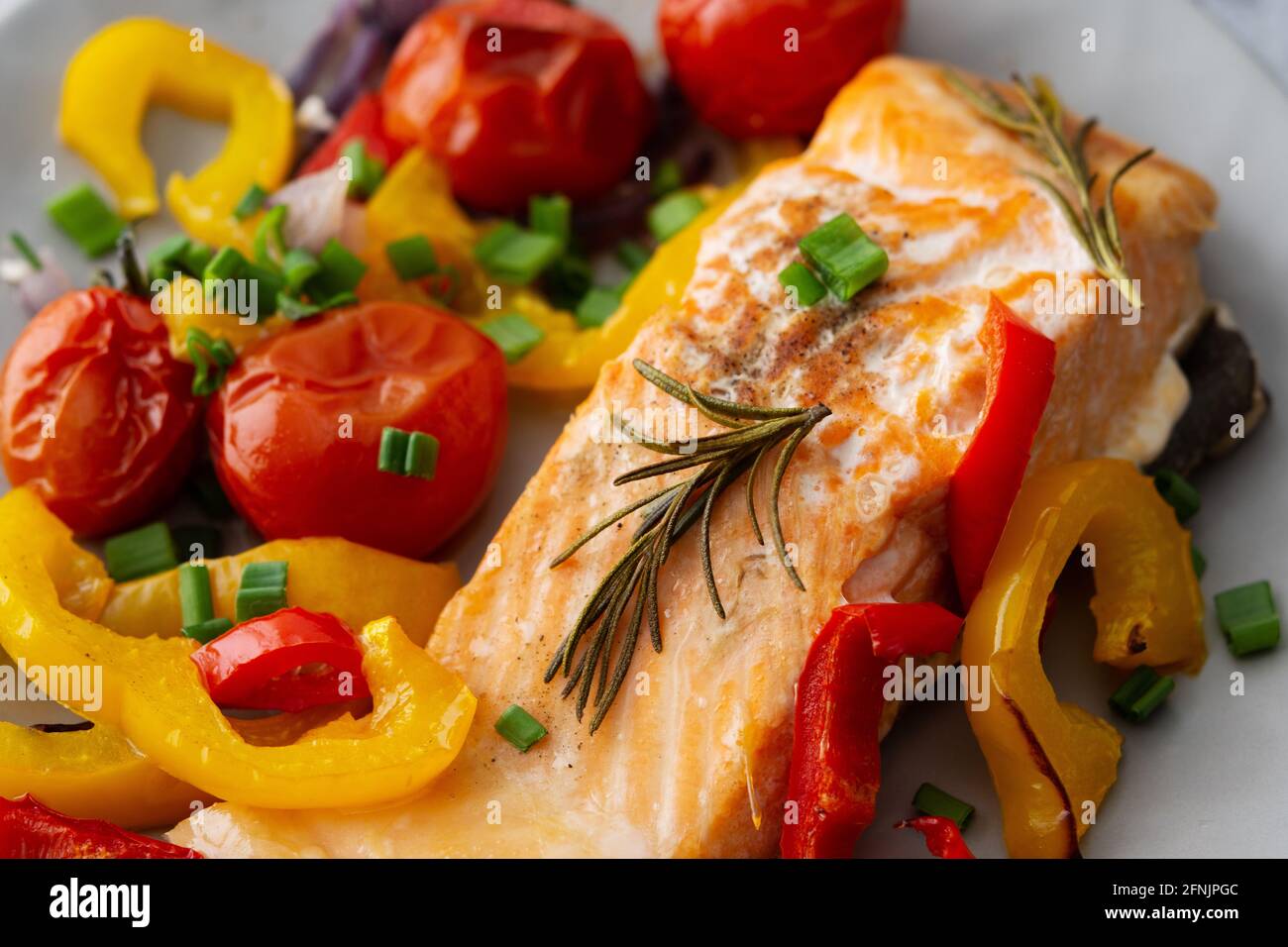 Gebackenes rotes Fischfilet Arktischer Saibling auf einem Teller mit Gemüse aus nächster Nähe, leckeres herzhaftes, gesundes Abendessen Stockfoto