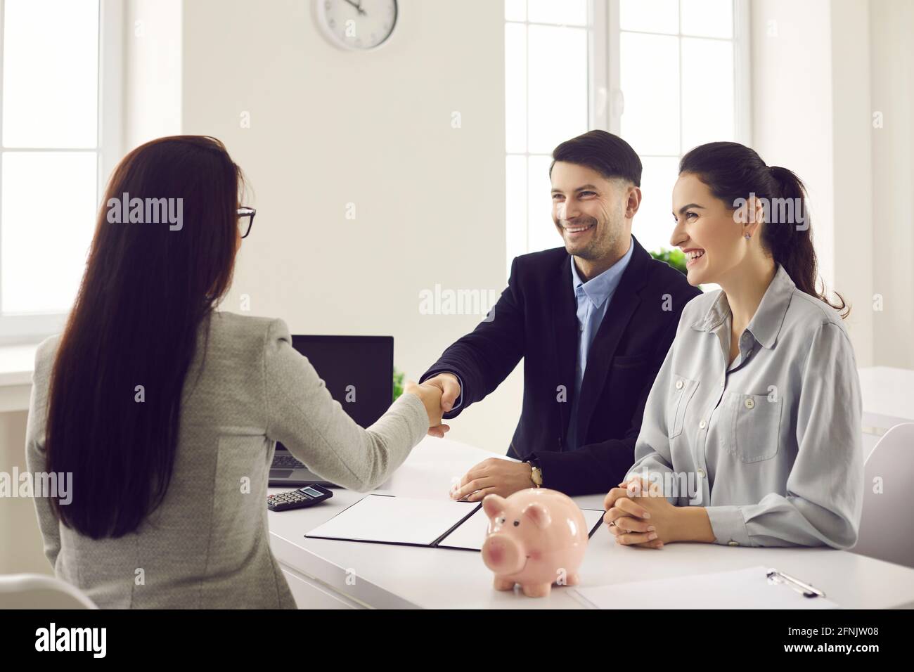 Happy Millennial Paar Kunden Handshaking mit Frau Bankarbeiter Versicherer Stockfoto