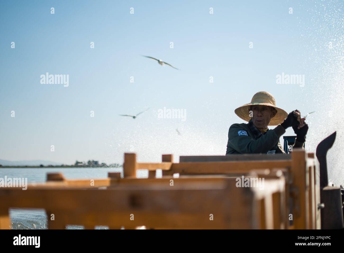 Inle Lake, Nyaung Shwe, Shan State, Myanmar - Januar 7 2020: Porträt eines männlichen Kapitäns, der ein traditionelles Boot im Kanal fährt Stockfoto