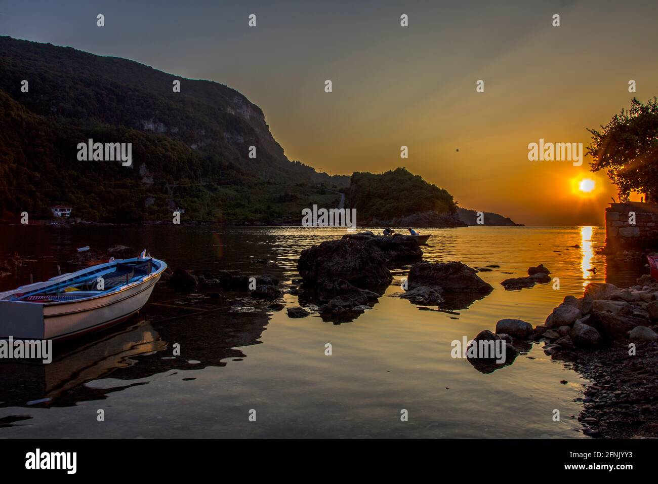 Hochauflösende Sonnenuntergangsansicht der Stadt Rize in der Türkei. Das einzigartige Bild, das durch die Schatten am Strand entsteht, verschönert das Ende des Tages. Stockfoto