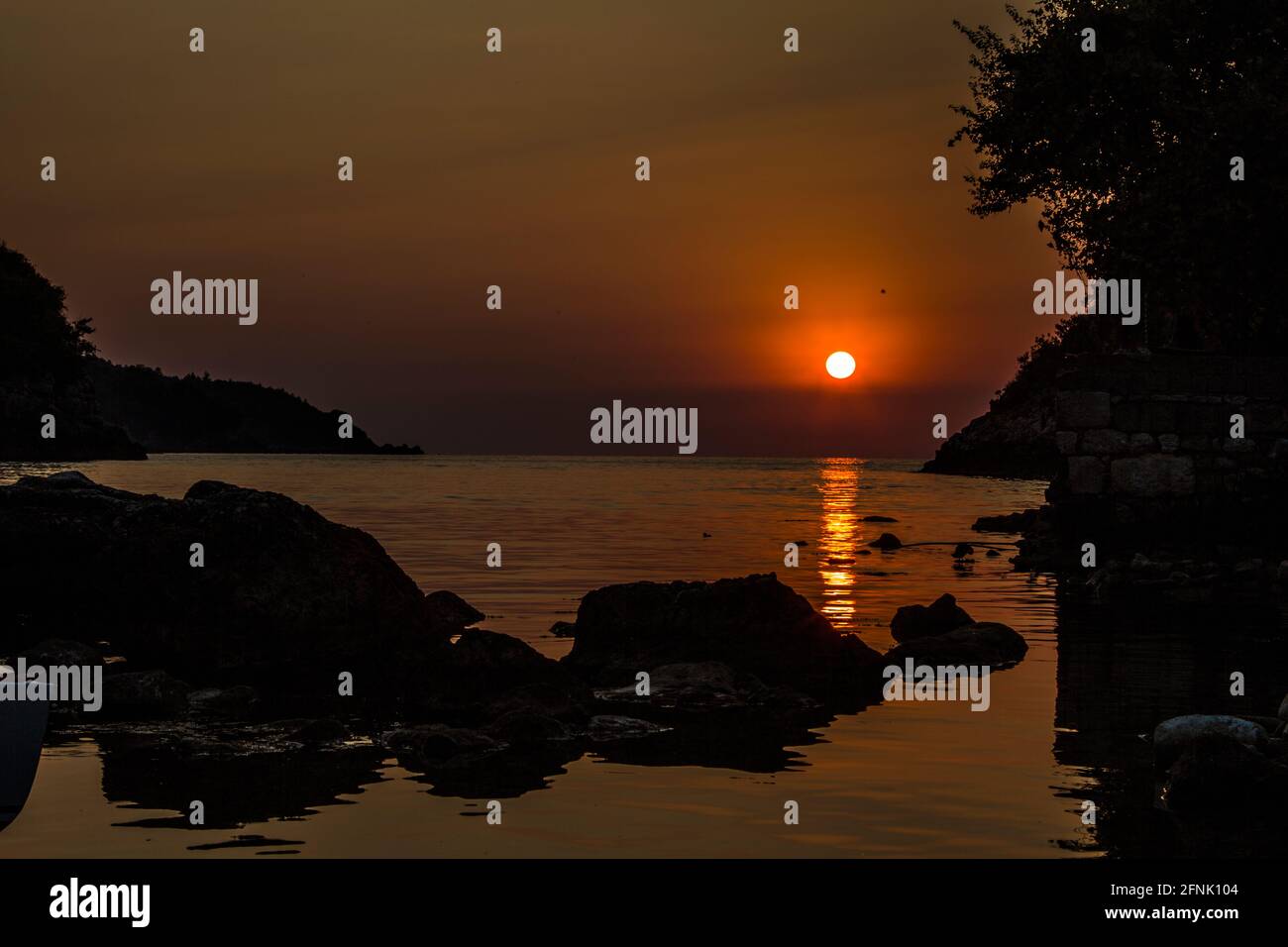 Hochauflösende Sonnenuntergangsansicht der Stadt Rize in der Türkei. Das einzigartige Bild, das durch die Schatten am Strand entsteht, verschönert das Ende des Tages. Stockfoto
