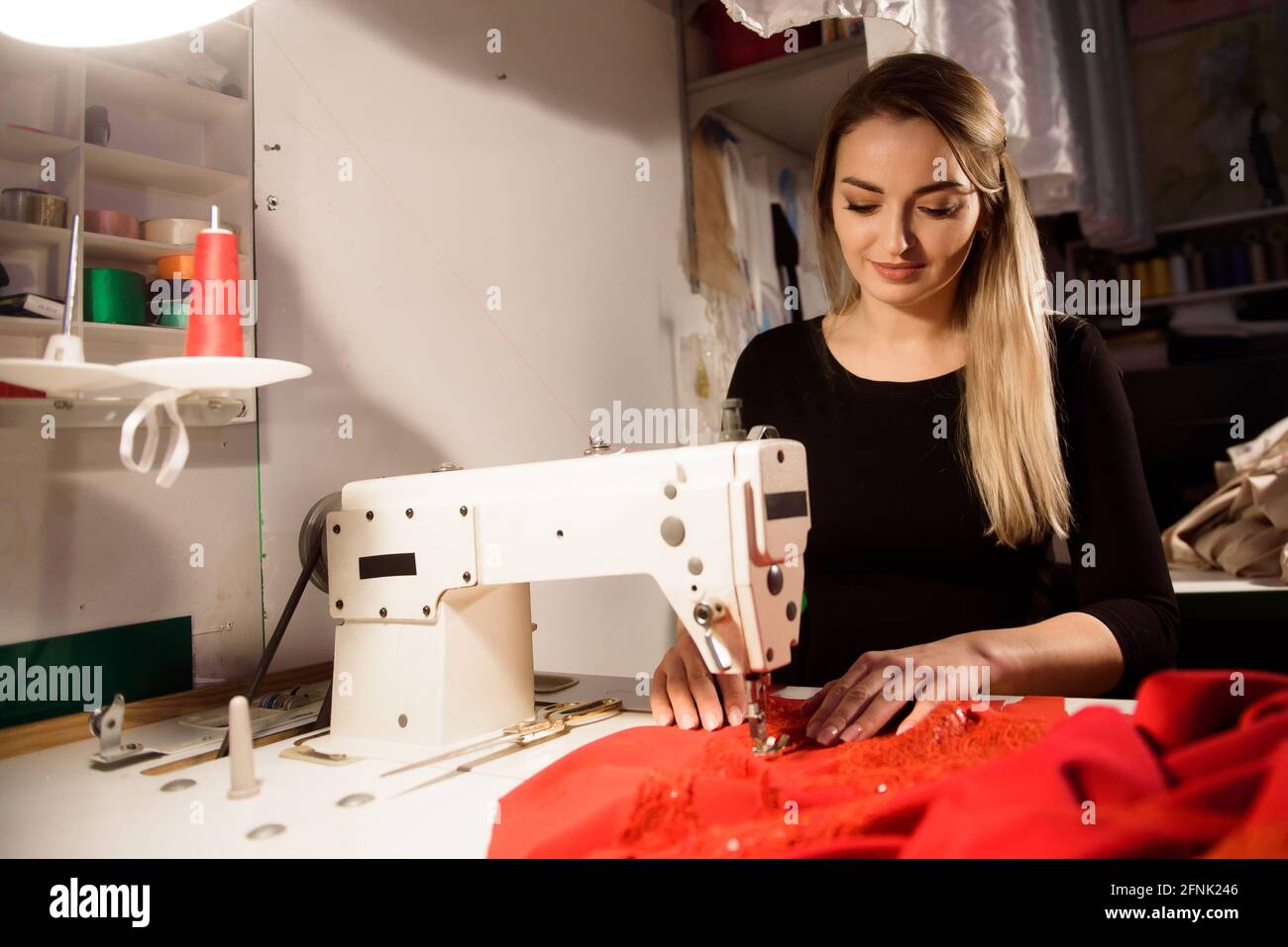 Prozess des Nähens im Atelier oder in der Werkstatt. Schneiderei und Reparatur von Kleidung, selbständiger Mitarbeiter. Stockfoto