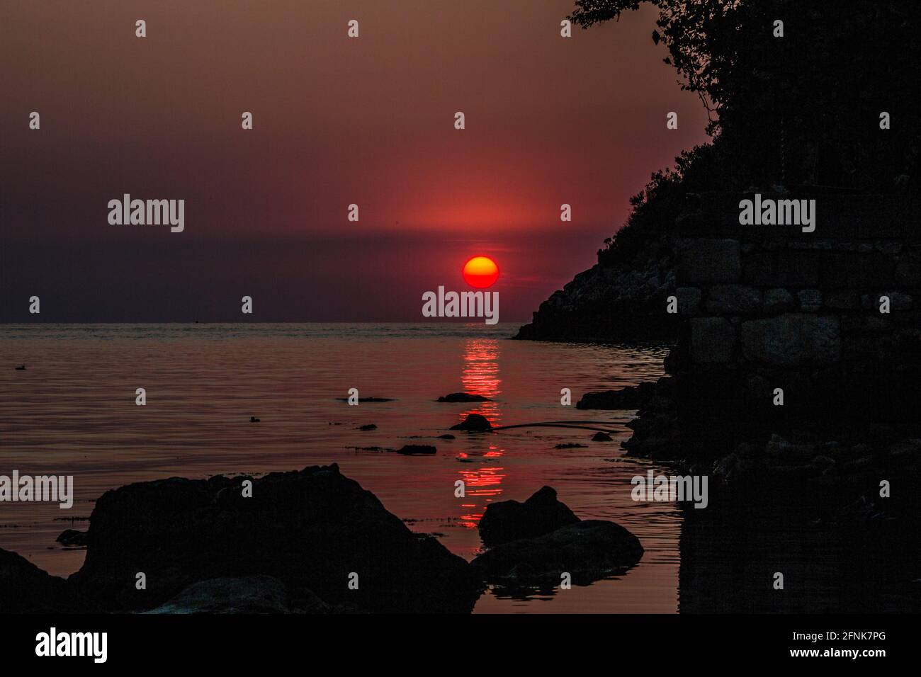Hochauflösende Sonnenuntergangsansicht der Stadt Rize in der Türkei. Das einzigartige Bild, das durch die Schatten am Strand entsteht, verschönert das Ende des Tages. Stockfoto