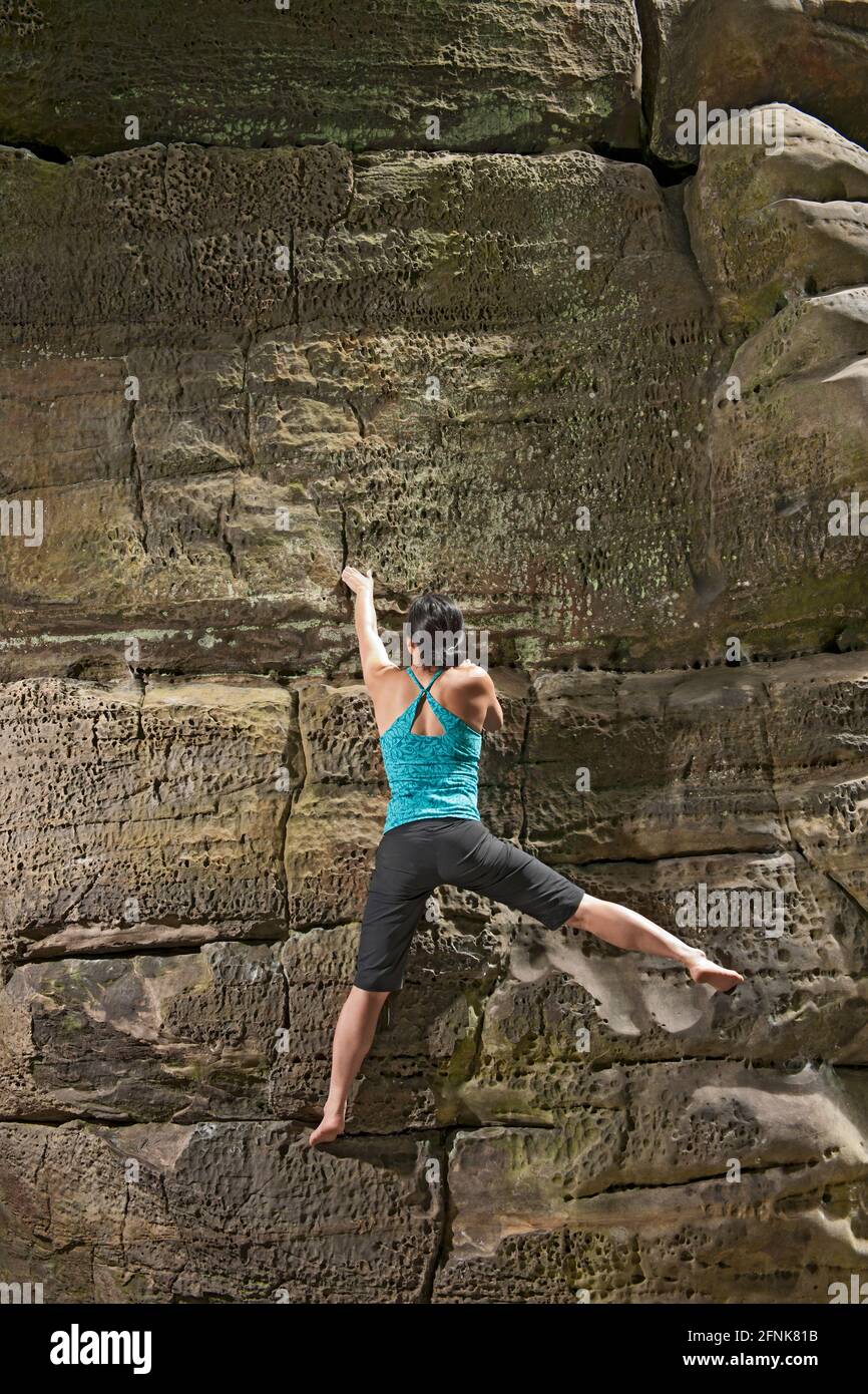 Frau beim Bouldern auf den Sandsteinfelsen bei Harrisons Rock in England Stockfoto