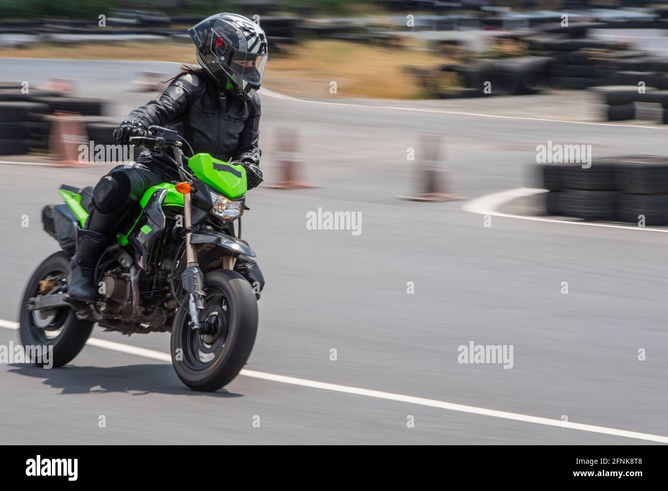 Frau übt auf ihrem Motorrad auf der Rennstrecke in Bangkok Stockfoto