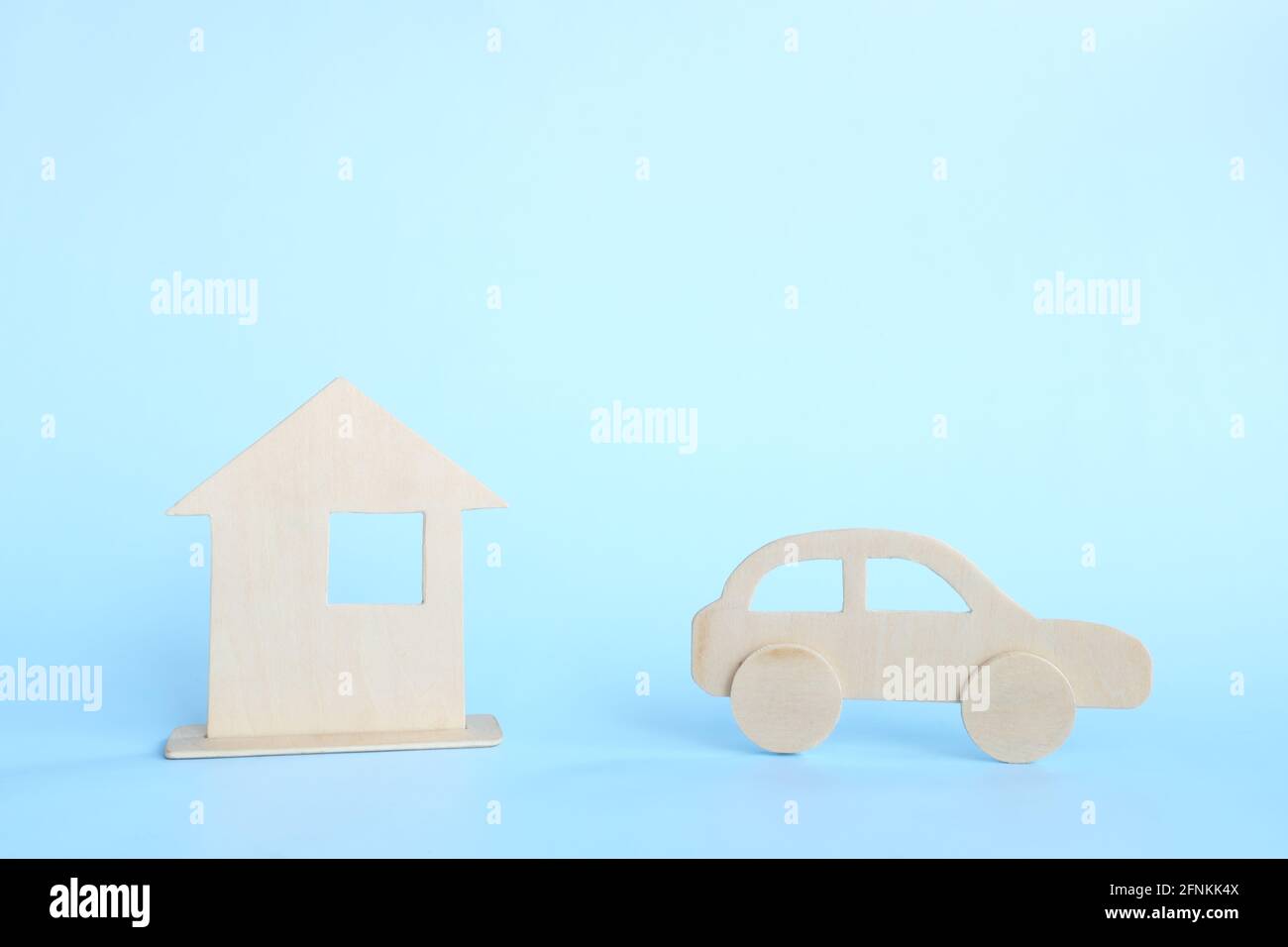 Haus- und Fahrzeugbesitzkonzept. Vorrangiges Dilemma bei der Wahl zwischen dem Kauf eines Hauses oder eines Autos. Stockfoto