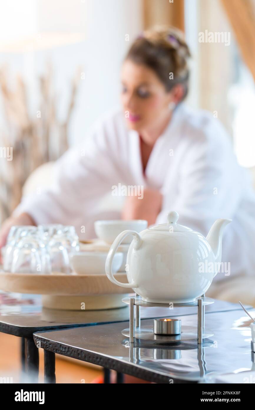 Frau im Bademantel Teetrinken im Wellness-Spa-Ruheraum Stockfoto