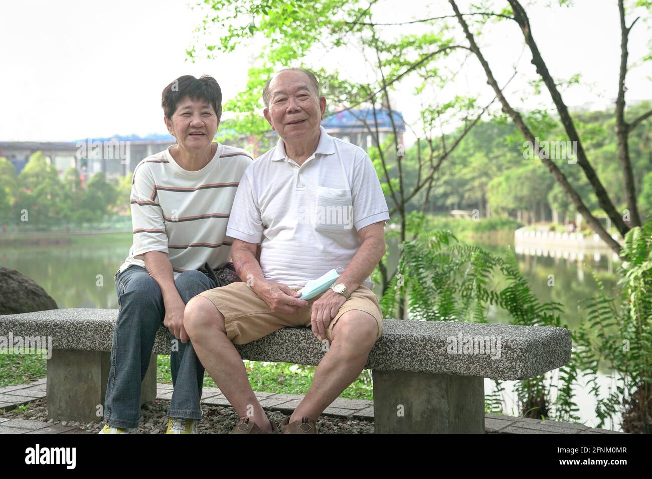 Glücklich lächelndes älteres asiatisches Paar im Park. Lifestyle nach dem Ruhestand Konzept. Stockfoto