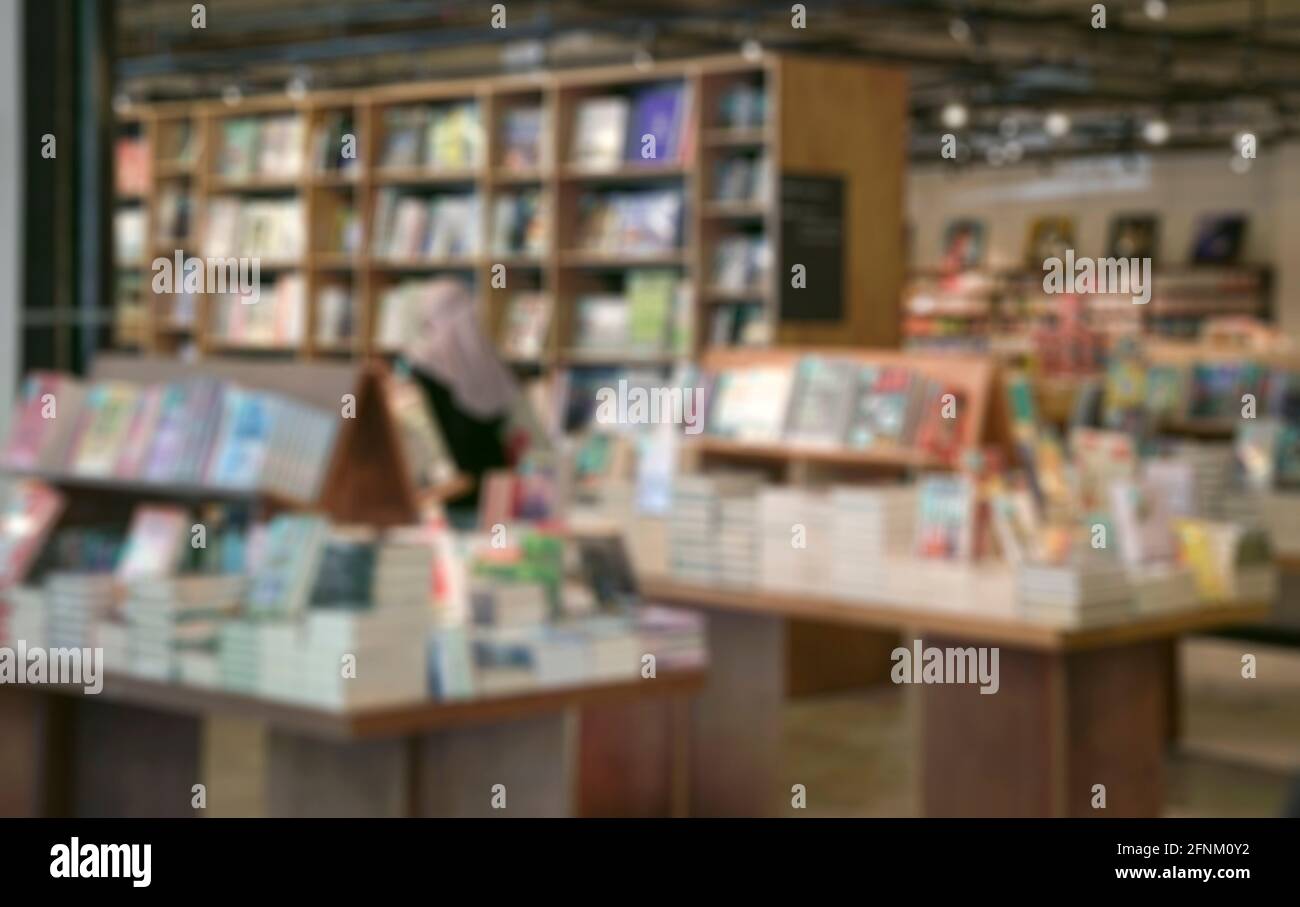 Buchhandlung mit Shopper mit Bücherstapel. Unschärfe-Unschärfe. Stockfoto