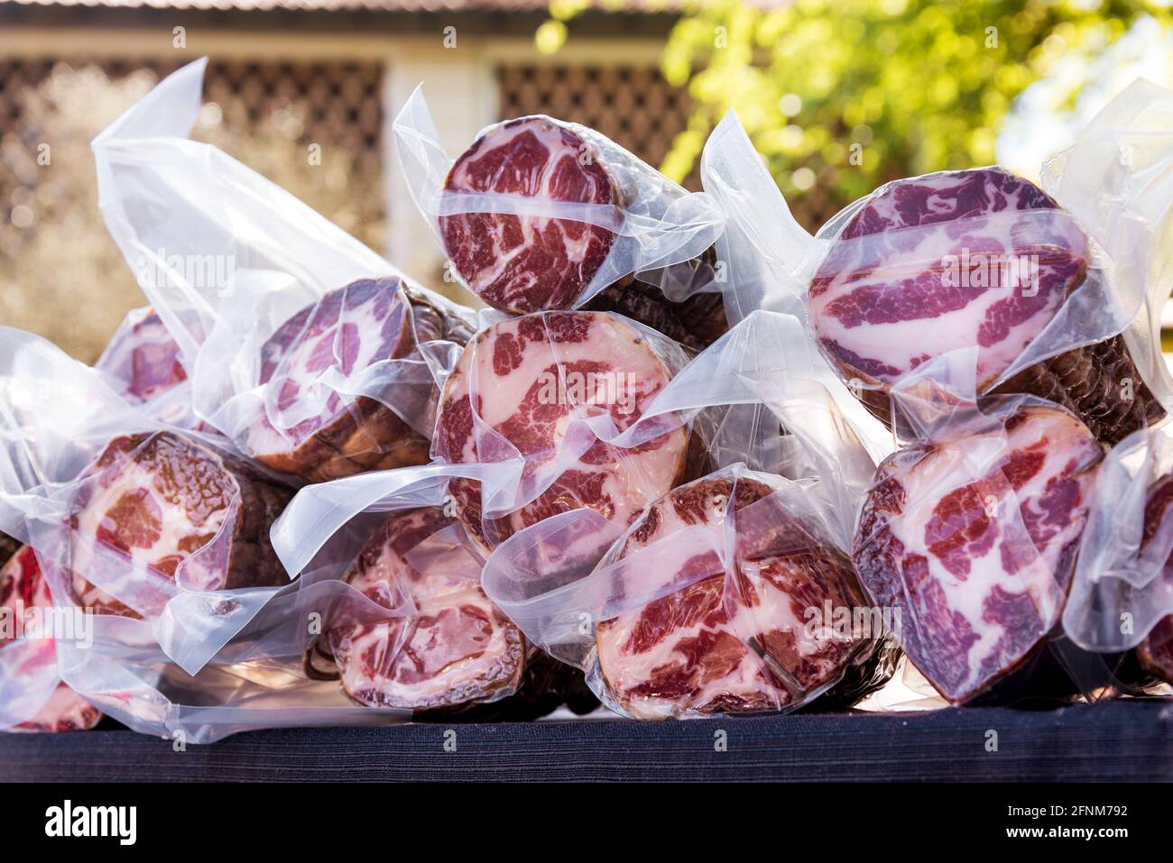Präsentation von vakuumverpackten ausgehärteten coppa Schinken zum Verkauf im Freien auf dem Markt oder einer Metzgerei, italienische regionale Spezialität Stockfoto