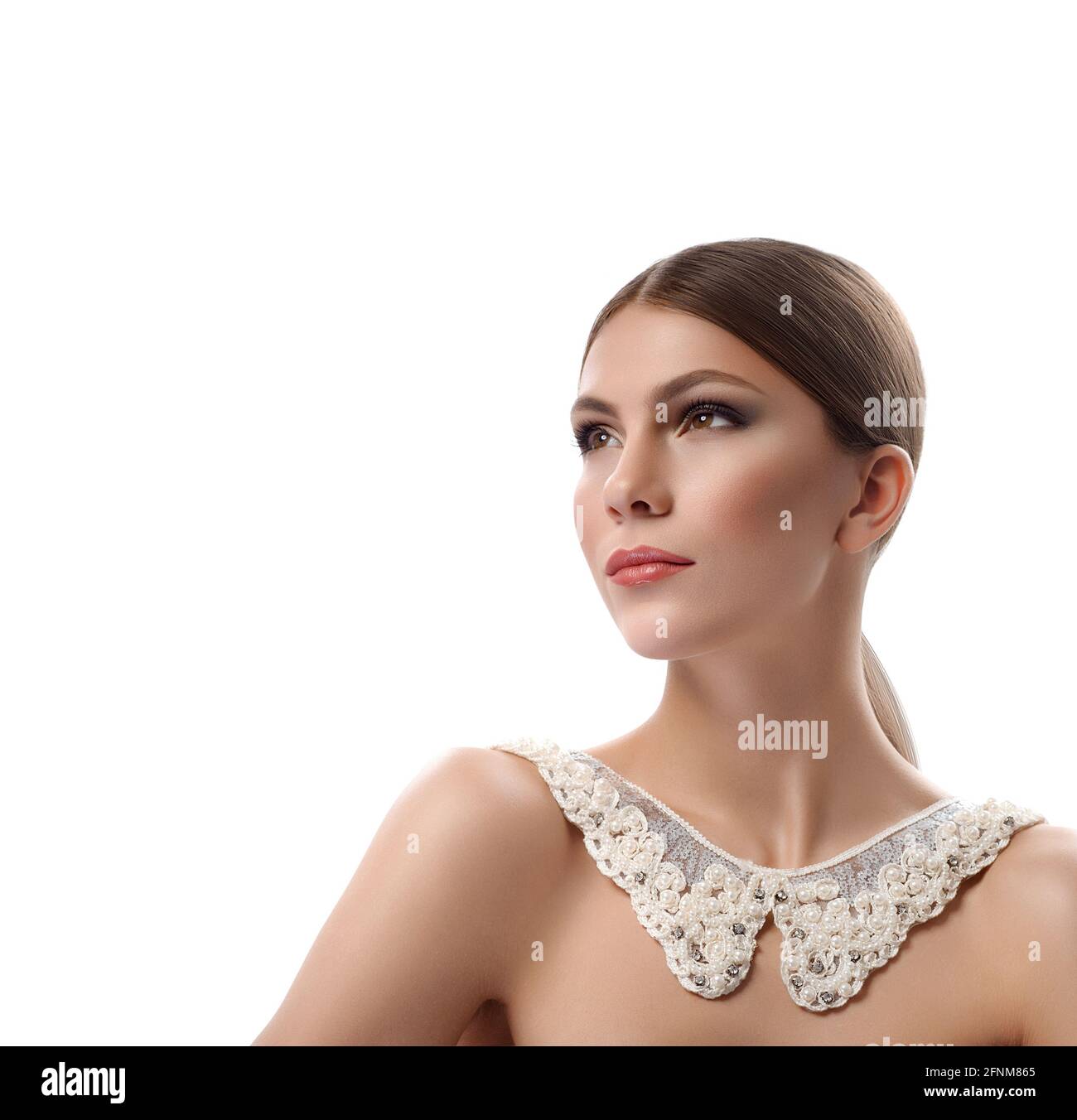 Sie ist eine Diva. Beschnittene Studioaufnahme einer eleganten jungen, schönen Frau, die professionelles Make-up und eine halskette mit lacey-Kragen trägt, die mit Perlen davonschaut und anmutig isoliert auf weißem Copyspace posiert Stockfoto