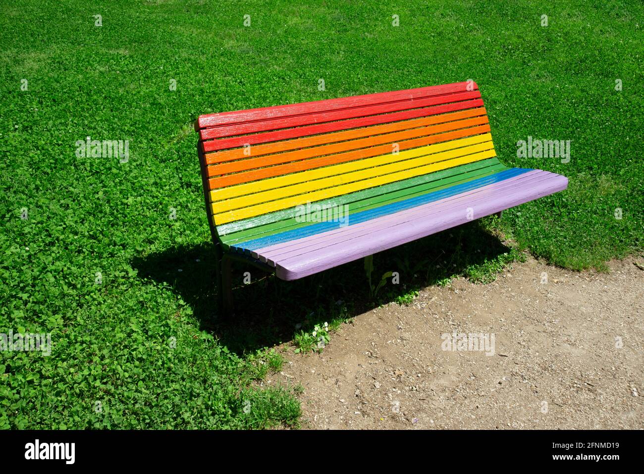 In Regenbogenfarben lackierte Bank im Park Stockfoto