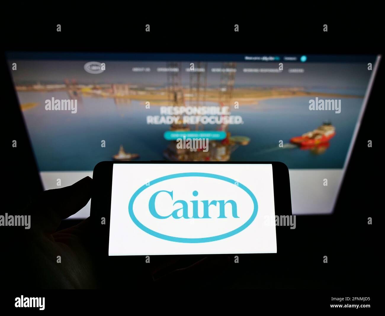 Person, die ein Smartphone mit dem Logo des britischen Öl- und Gasunternehmens Cairn Energy plc auf dem Bildschirm vor der Website hält. Konzentrieren Sie sich auf die Telefonanzeige. Stockfoto