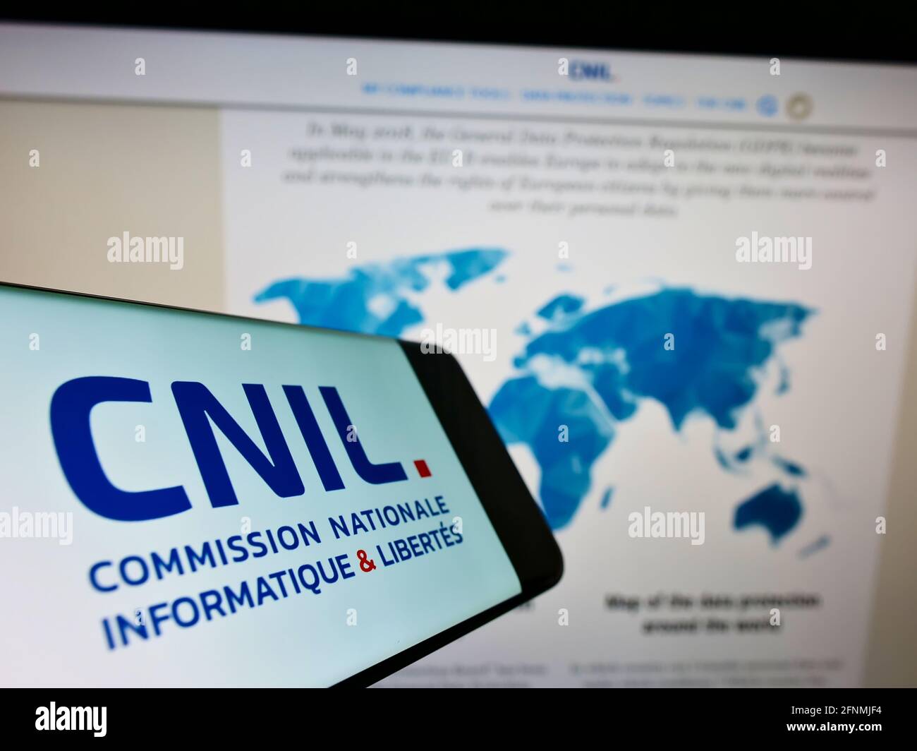 Smartphone mit Logo der französischen Regulierungsbehörde CNIL (Datenschutz) auf dem Bildschirm vor der Website mit Karte. Konzentrieren Sie sich auf die Mitte des Telefondisplays. Stockfoto