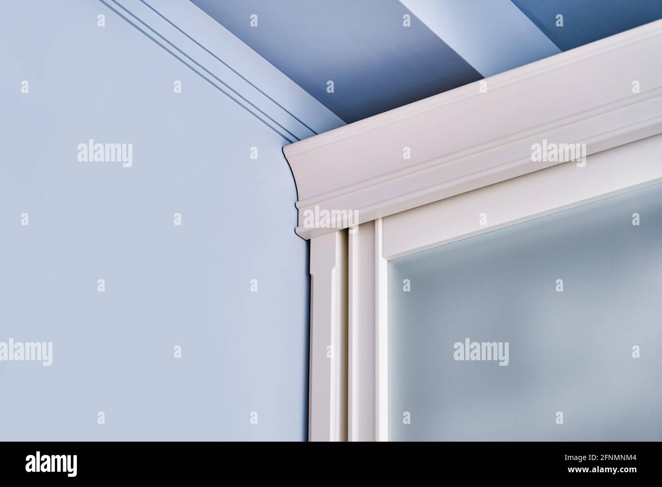 Stilvolles Garderobenoberteil mit mattem Glas auf Schiebetüren stehend Nahe der blauen Wand Nahaufnahme Stockfoto