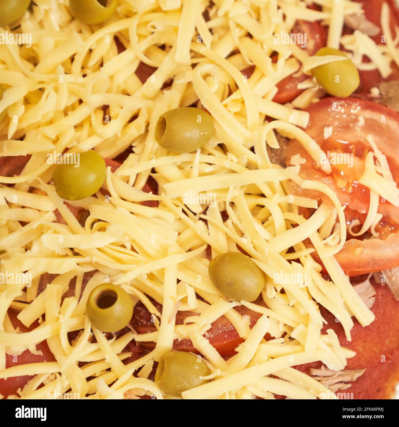 Pizza mit Rindertomate, Käse und Oliven zum Backen zubereitet. Gesunde glutenfreie Pizza. Glutenfreier Kochkurs. Stockfoto