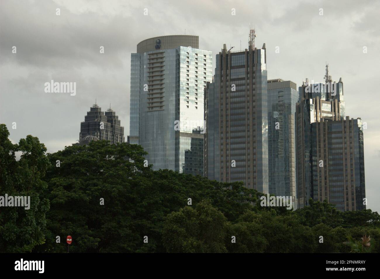 Hoch aufragende Gebäude in der Sudirman Street aus einem Park im Senayan Sports Complex (Gelora Bung Karno), Jakarta, Indonesien. Stockfoto