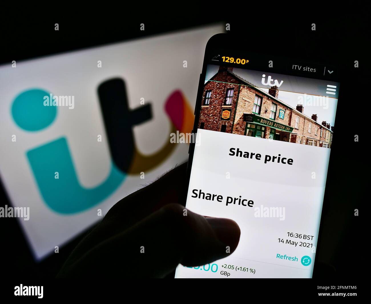 Person, die Mobiltelefon mit einer Webseite des britischen Fernsehunternehmens ITV plc auf dem Bildschirm vor dem Logo hält. Konzentrieren Sie sich auf die Mitte des Telefondisplays. Stockfoto