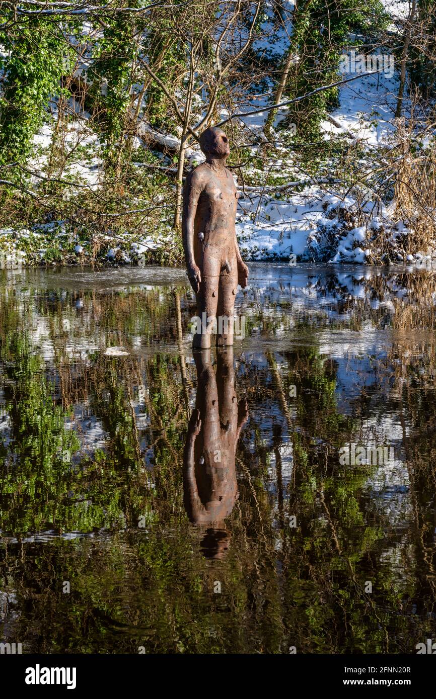 Nr. 2 von sechs lebensgroßen gusseisernen Skulpturen des Künstlers Antony Gormley mit dem Titel „6 Times“ on the Water of Leith in Edinburgh, Schottland, Großbritannien Stockfoto