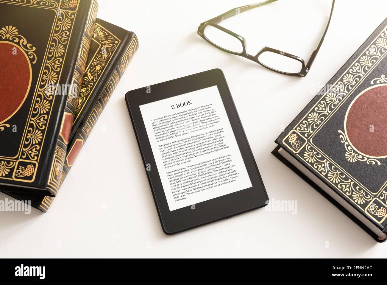 E-Book-Reader mit traditioneller Buchkomposition. Lesen von Büchern mit E-Book-Gerätekonzept Stockfoto
