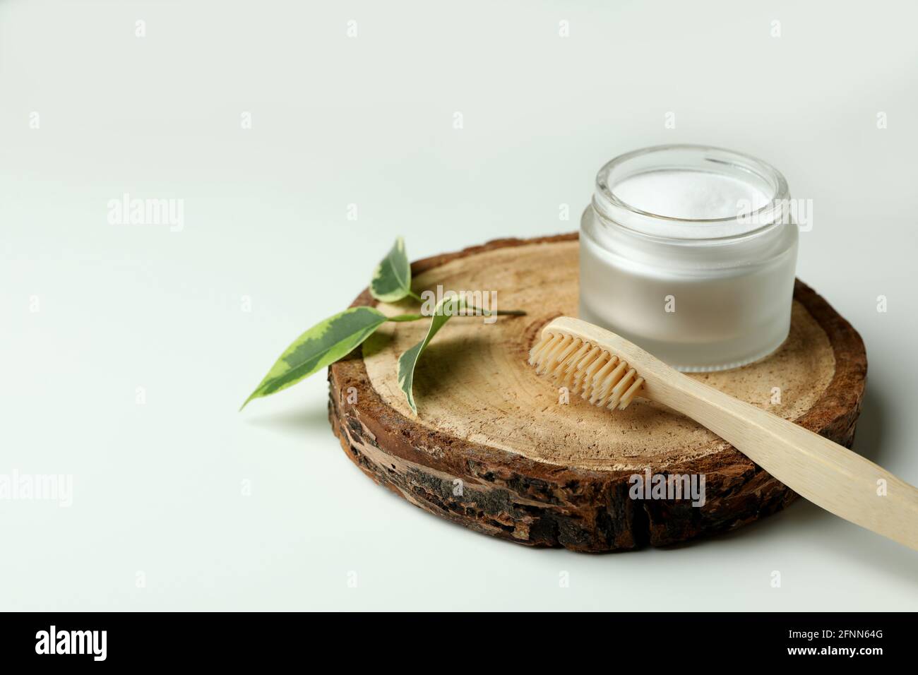 Brett mit umweltfreundlicher Zahnbürste und Zahnpulver auf weiß Hintergrund Stockfoto